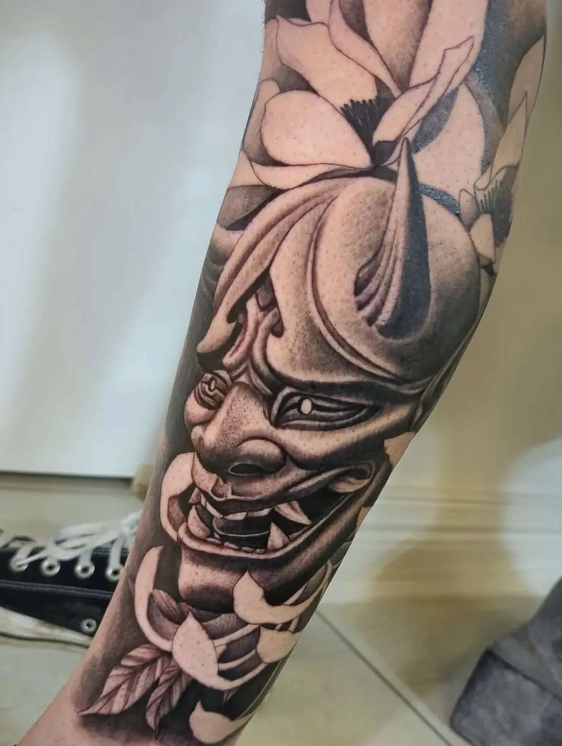 Detailed Japanese hannya mask tattoo with ornamental elements